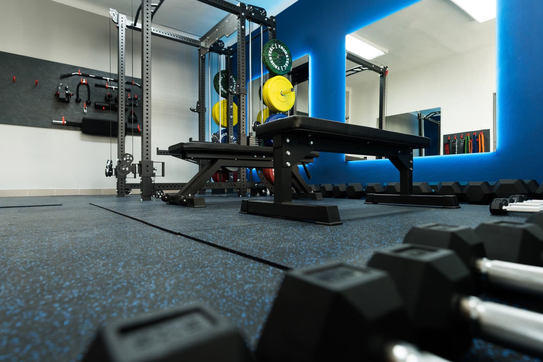 Jednoručky a tréninkové lavice v soukromé posilovně JimGym